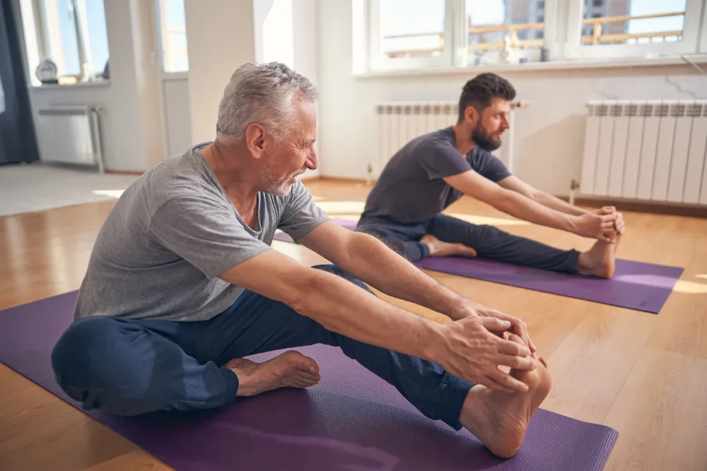 Deux hommes faisant du yoga sur des tapis